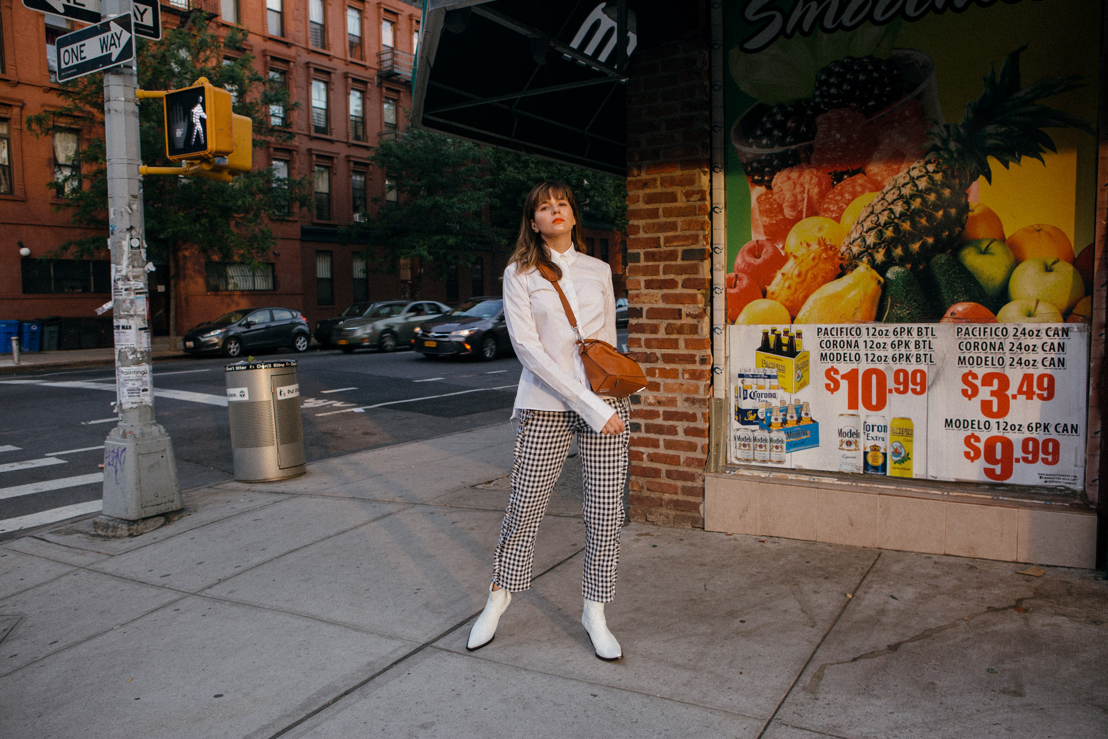 Maristella wears gingham pants with white cowboy boots and a button down shirt