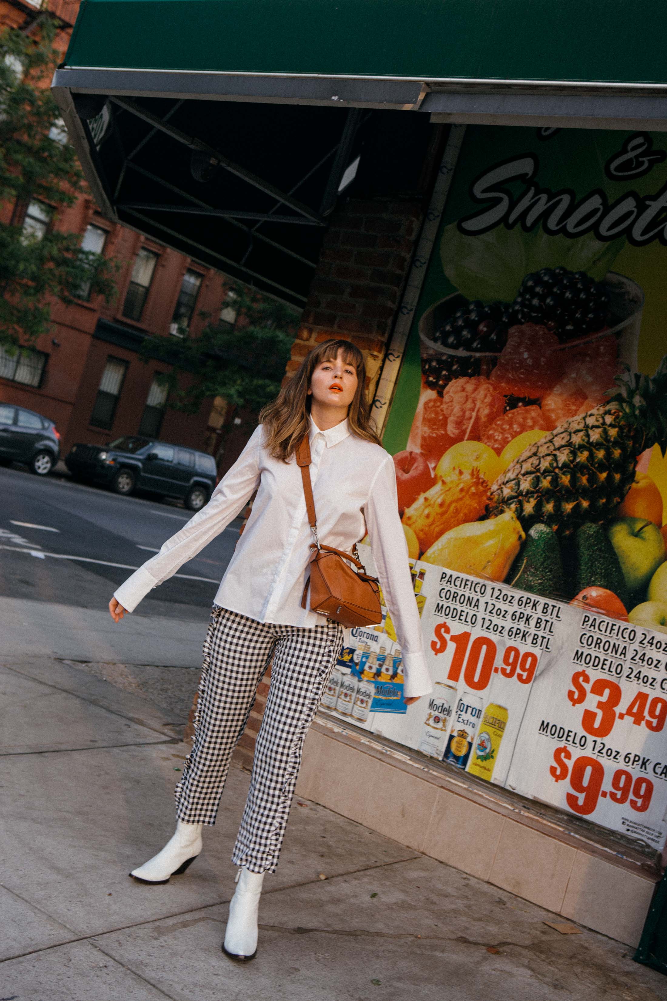 Maristella wearing gingham pants and a white button down shirt