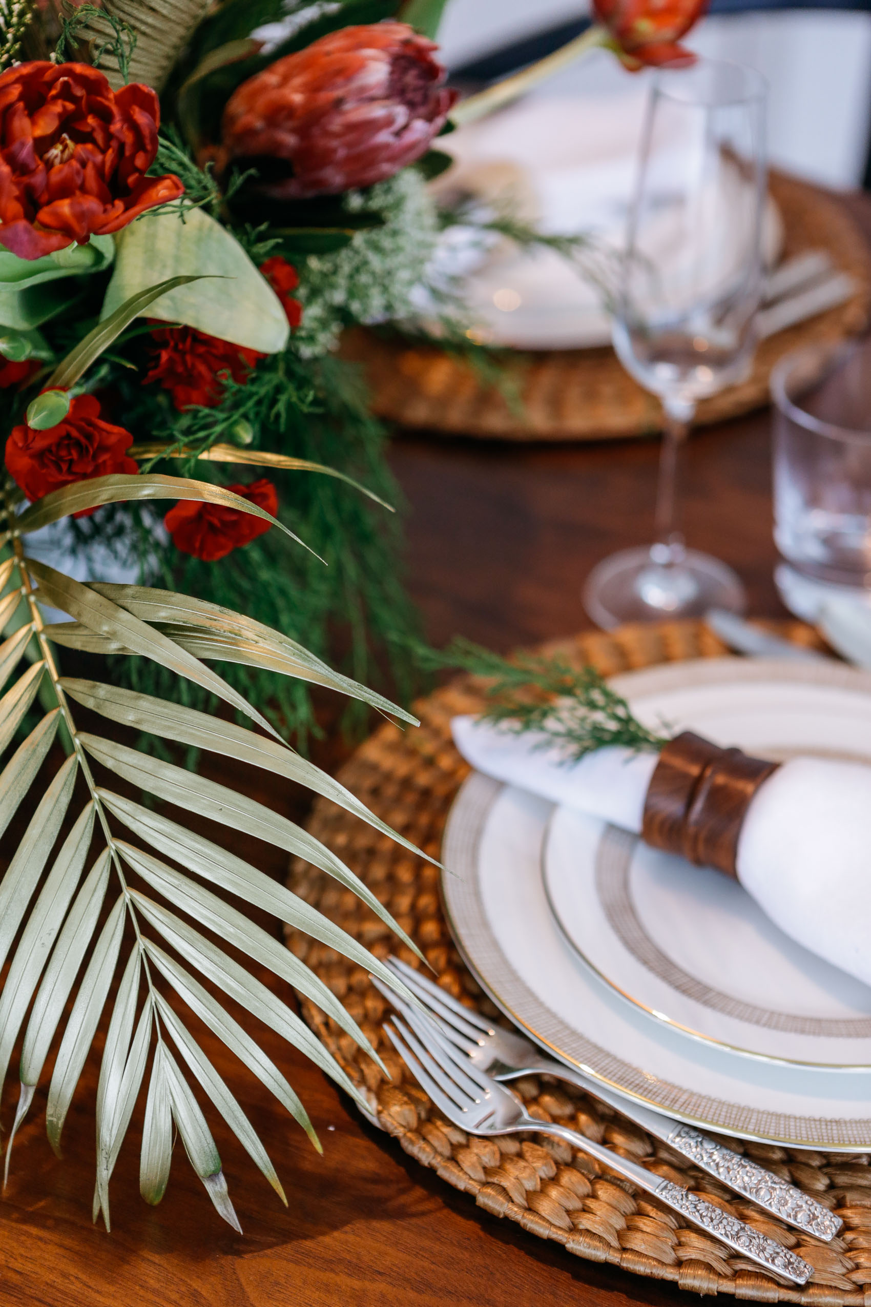 Tropical Christmas decoration with palm leafs painted in gold, straw and wood accessories