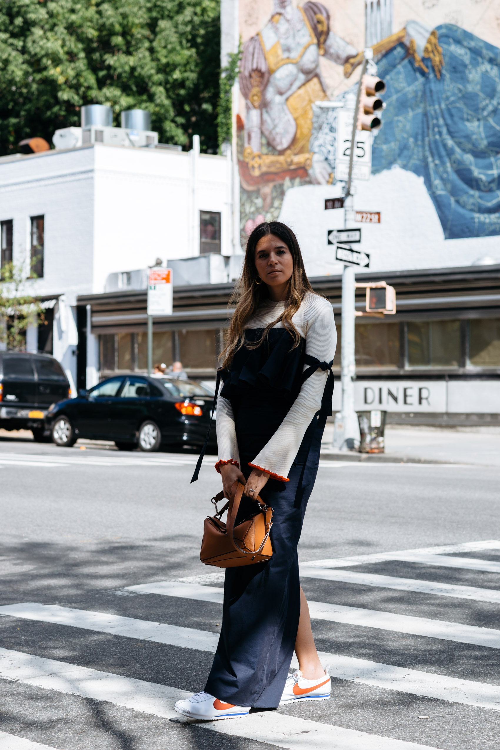 Maristella wearing a navy column dress with Nike Cortez classic sneakers and a Loewe puzzle bag