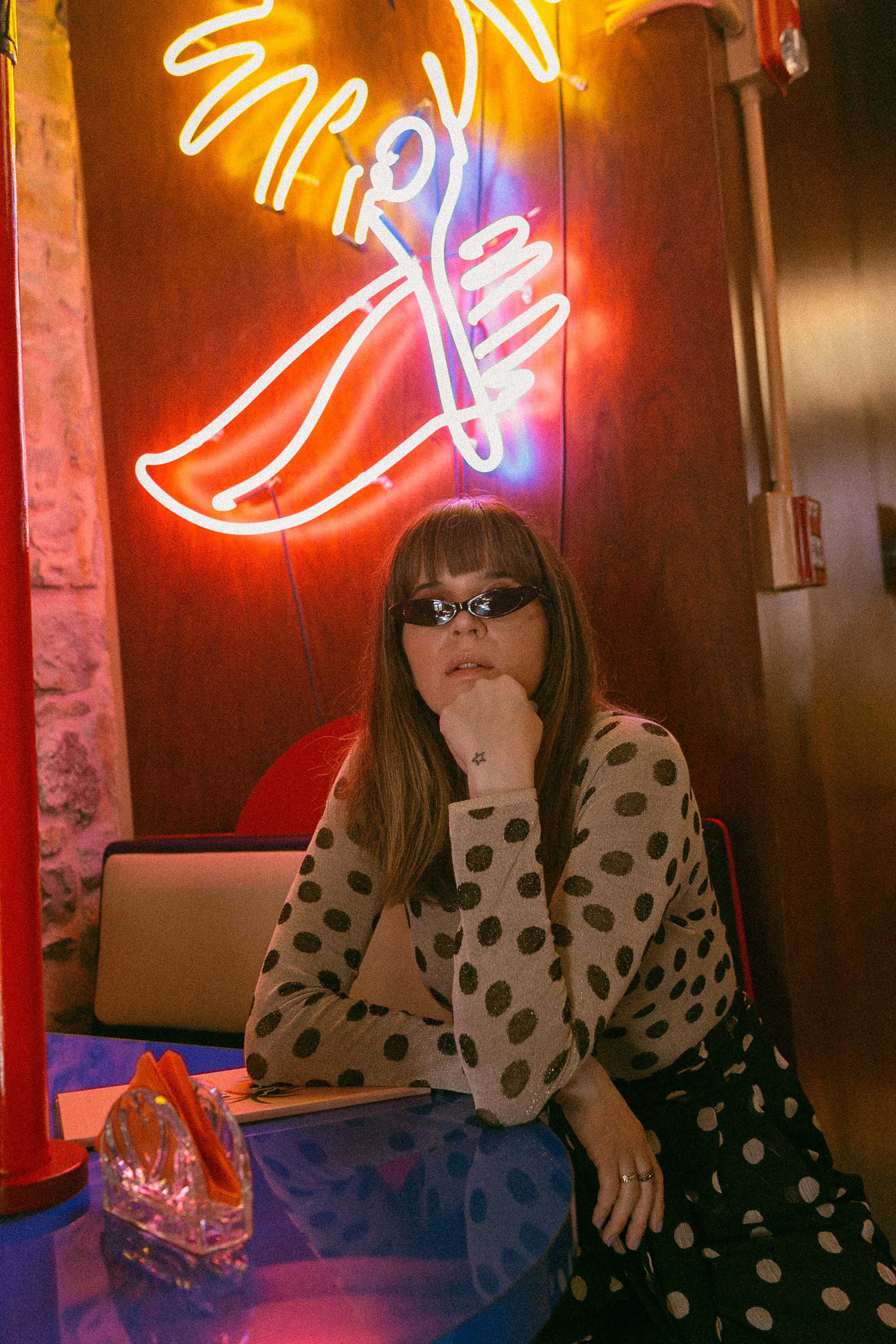 Maristella wears a Nanushka polka dot knit sweater and Giant Vintage Carolina skinny black sunglasses