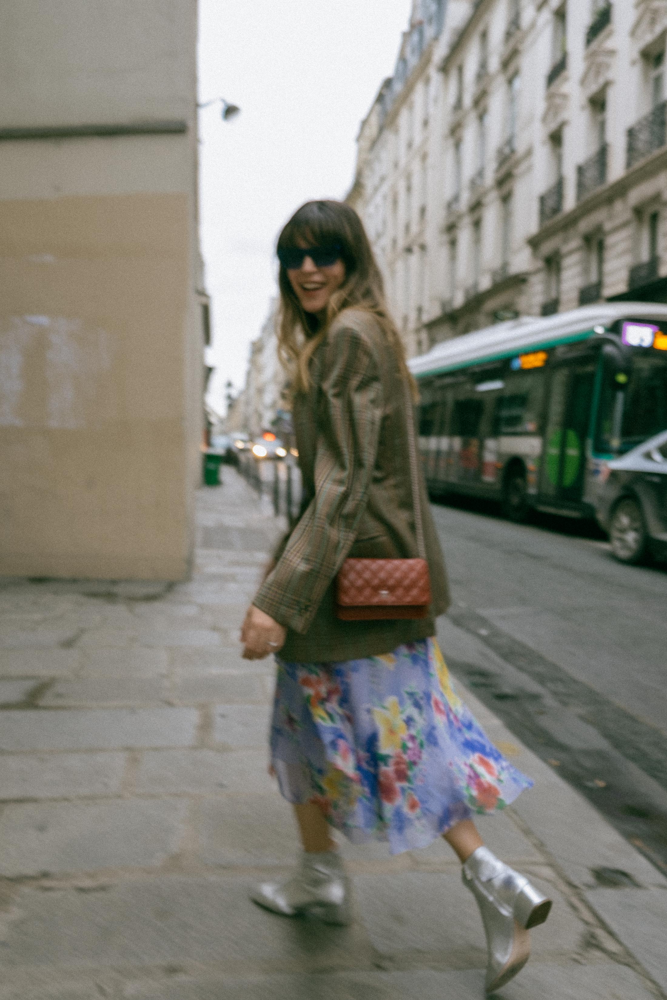 Maristella wears a vintage men's blazer, vintage floral dress, Loeffler Randall silver boots and mini burgundy Chanel crossbody bag in Paris