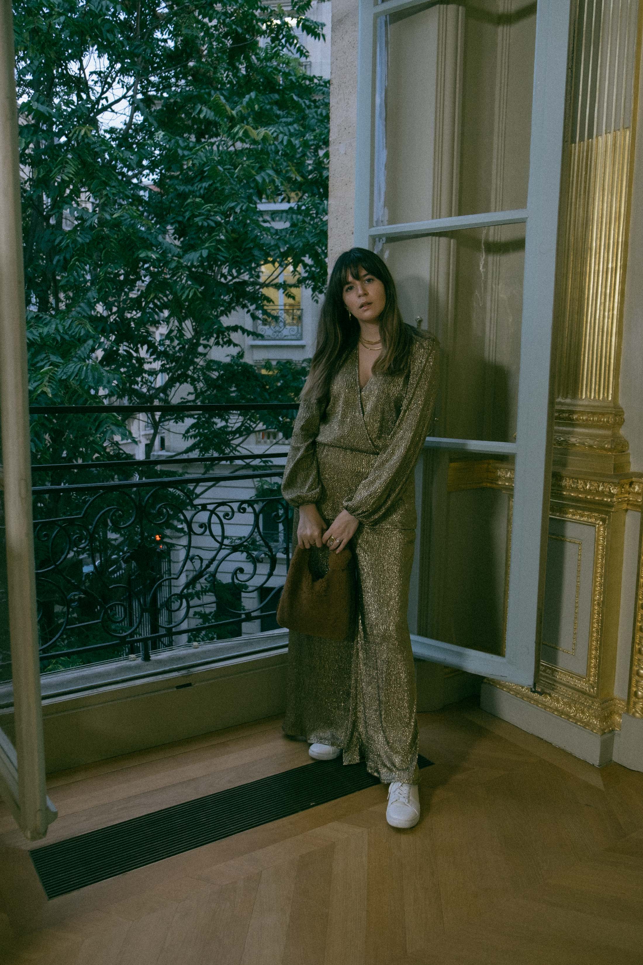 Maristella in a gold coordinated blouse and pants set with white sneakers and a teddy Loeffler Randall bag at the Ellery Presentation in Paris Fashion Week