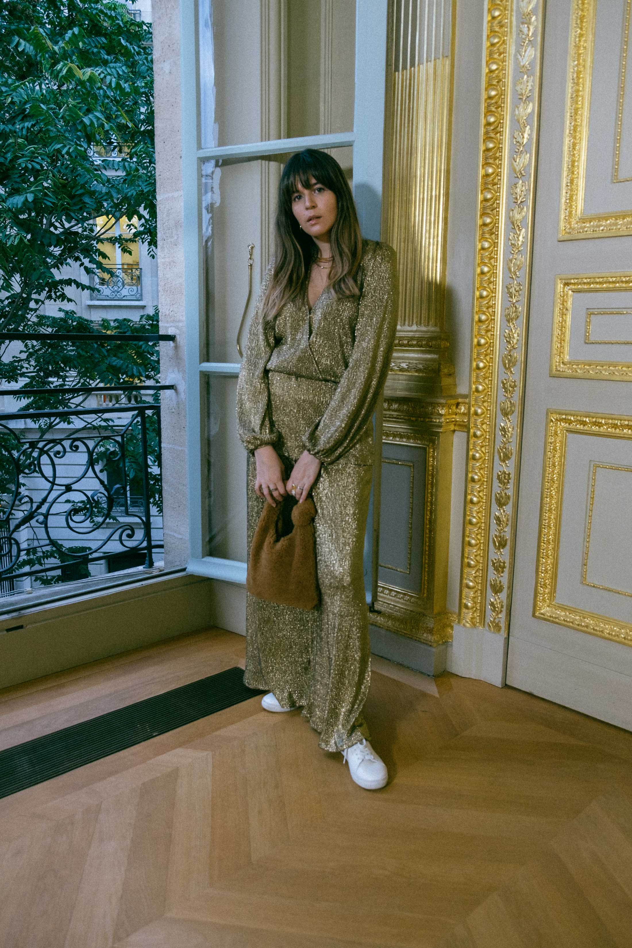 Maristella in a gold coordinated blouse and pants set with white sneakers and a teddy Loeffler Randall bag at the Ellery Presentation in Paris Fashion Week