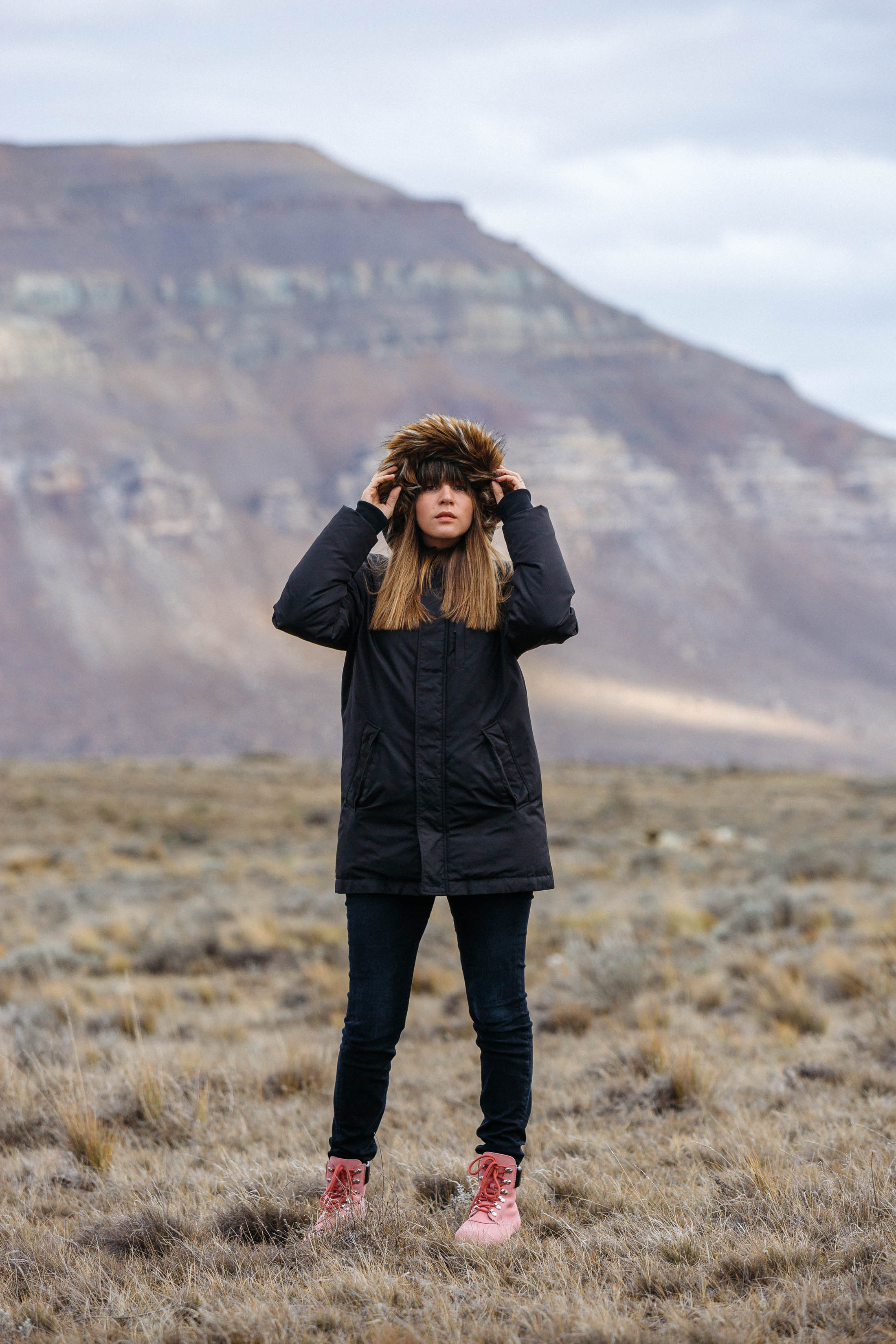 Maristella wears a fur trimmed hooded parka, black skinny jeans and Acne Telde boots in pink