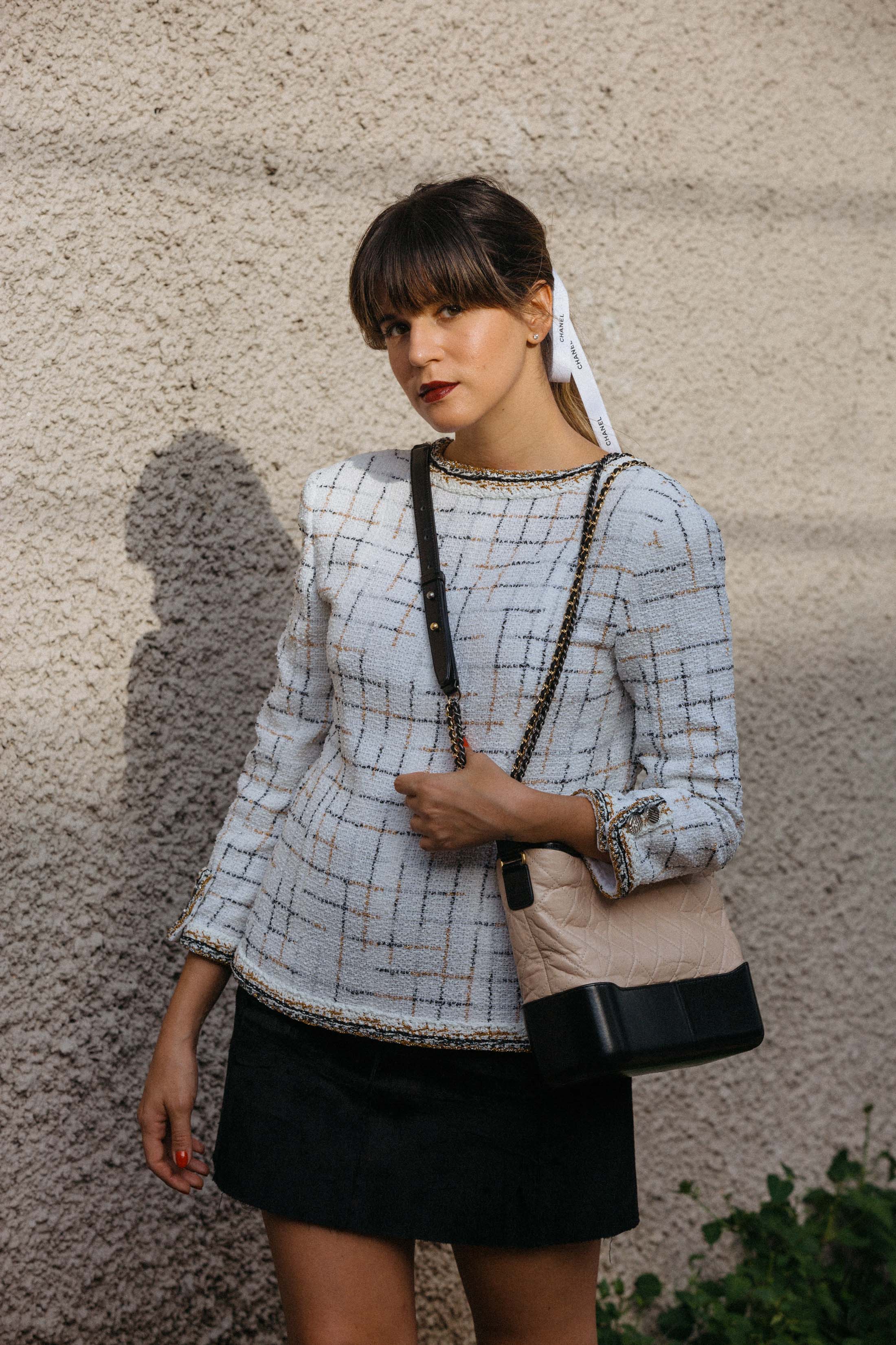 Maristella styles her bangs with a ponytail and Chanel ribbon and wears the Chanel Gabrielle bag in the V style