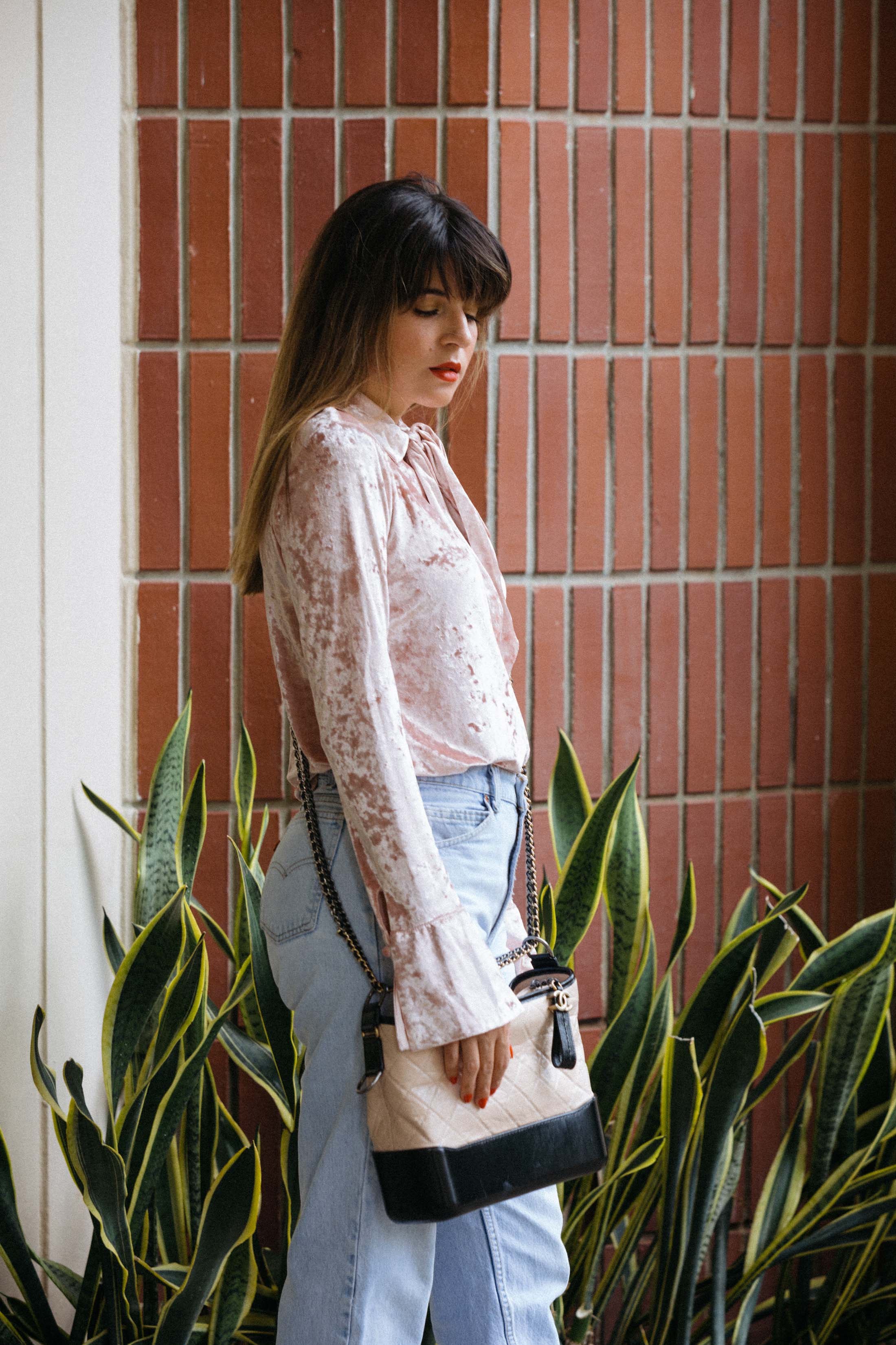 Pink velvet top, high rise jeans and Chanel two tone bag