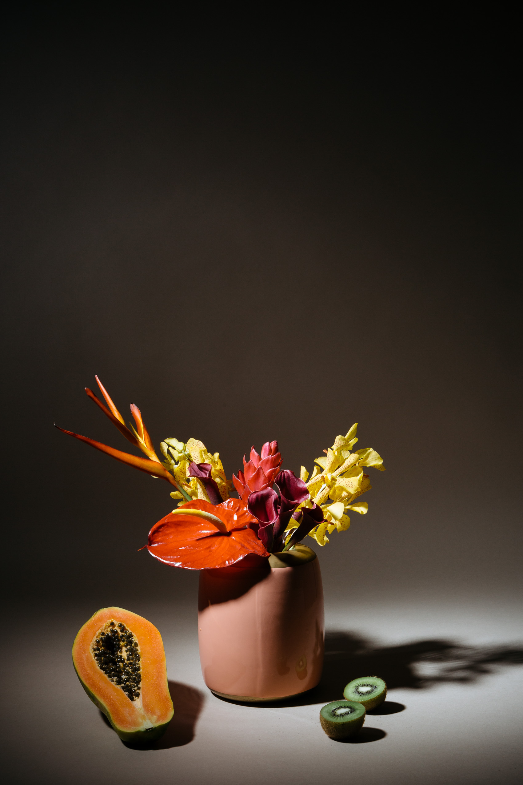 Tropical Floral arrangement with lobster claw, anthurium, orchids, ginger and cala lilies, papaya and kiwi still life